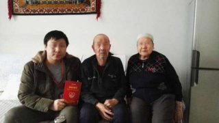 Xinjiang, photo d’un fonctionnaire han avec sa famille d’accueil ouïghoure prise après la signature de la « carte de famille d’accueil »