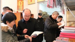 représentants du Bureau des Affaires ethniques et religieuses en pleine inspection des ouvrages religieux « illégaux » dans une église