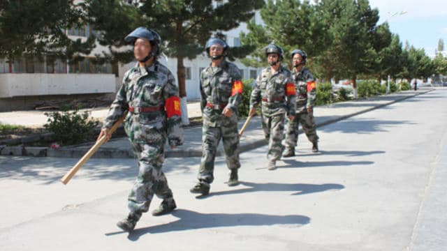 Des miliciens patrouillent dans les rues au Xinjiang.