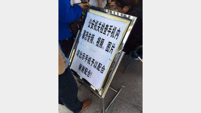 Un panneau d’avertissement à un poste-frontière au Xinjiang indiquant aux voyageurs passant la frontière que leur téléphone portable sera contrôlé. (Photo de Qiao Long, journaliste à Radio Free Asia)