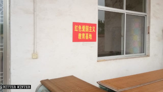 Plaque portant l’inscription « Base rouge d’éducation patriotique » à l’intérieur du « Temple du président Mao Bouddha »