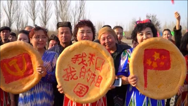 Des pains « naan » « ouïghours », de la gauche vers la droite, « ornés » de la faucille et du marteau du PCC, du slogan « mon pays et moi » et du drapeau chinois, lors du Nouvel An chinois dans la ville de Turpan, dans le Xingjiang.