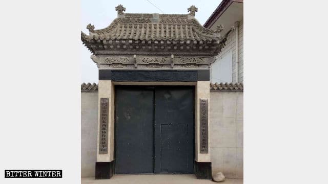 Portail de la mosquée remplacé par un portail en fer ordinaire, et deux nouvelles enseignes signalent que le bâtiment n’est plus une mosquée.