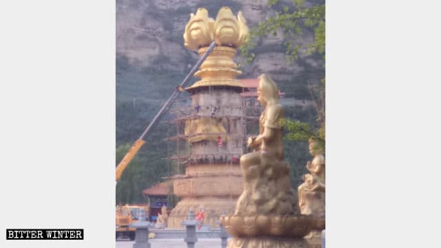 Des ouvriers démolissent la statue de Guanyin au temple de Xiaozai.