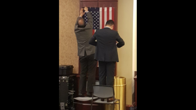Les Ouïghours accrochent le drapeau américain au mur pour la cérémonie d’ouverture au Centre d’accueil des visiteurs du Capitole américain