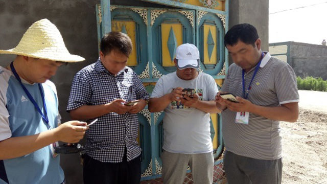 Les gens utilisent l’application « Visite dans le Xinjiang »