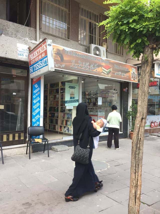 Une « veuve » ouïghoure passant devant une librairie ouïghoure à Istanbul.