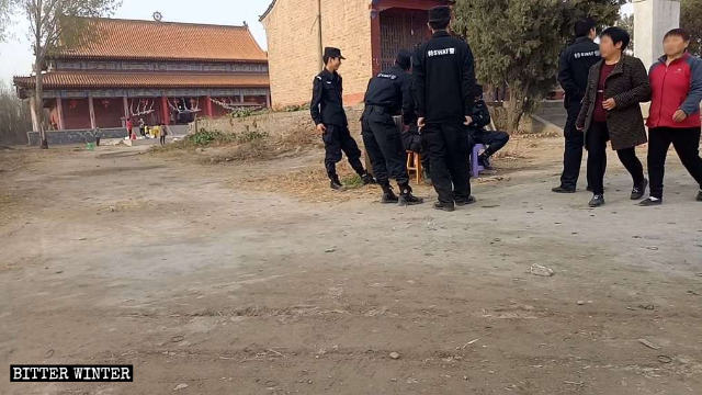 Des agents de police montant la garde devant le temple Gulingshan.
