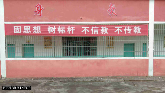 Une banderole portant l’inscription « Ne croyez pas en la religion, ne propagez pas la religion » affichée sur le mur d’une école.