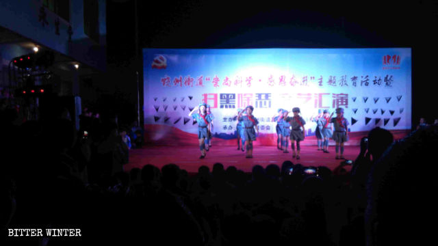 Des enfants interprètent des chants et des danses qui font l’éloge du Parti communiste.