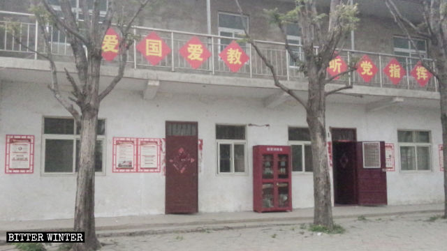 Les huit caractères chinois signifiant « Aimez votre pays, aimez votre religion et obéissez aux ordres du Parti » sont affichés sur la rambarde de l’église.