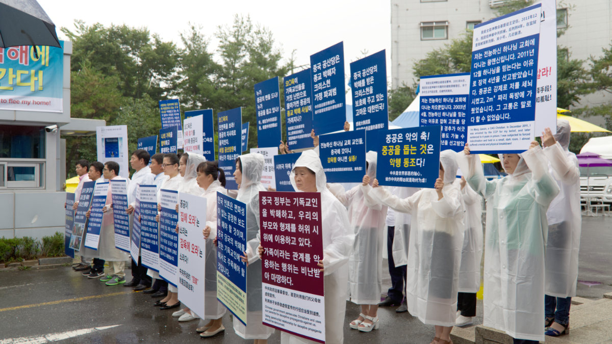 Des membres de l’EDTP, tenant des pancartes à l’entrée des locaux de l’EDTP à Onsu, protestent contre le PCC pour avoir utilisé des membres de leur famille afin d’organiser de fausses manifestations.