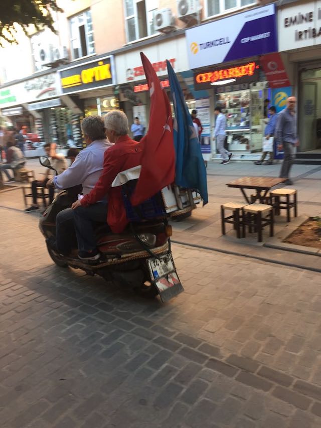 Des motocyclistes ouïghours arborent le drapeau turc et le drapeau du Turkestan à l’arrière de leur moto.