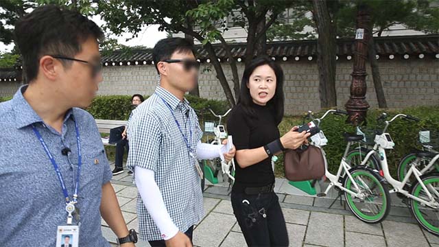 Mme O, irritée, a été arrêtée par des agents de sécurité alors qu'elle tentait de s’en prendre aux manifestants lors de la conférence de presse.