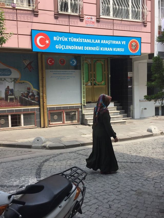 Une femme ouïghoure passe devant une petite madrasa (école coranique) dans le district de Ziyghur, à Zeytinburnu.