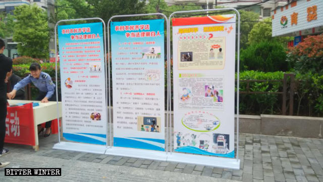 Des agents de la sécurité publique font la promotion de la campagne « Défendez la science, opposez-vous aux xie jiao » dans la rue.
