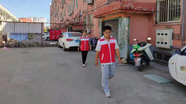 Des responsables de bloc en patrouillent dans une communauté, dans une localité de la province du Shandong.
