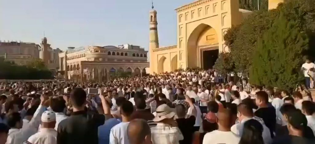 Des touristes chinois contemplent de fausses « danses sacrées » devant la mosquée Id Kah.
