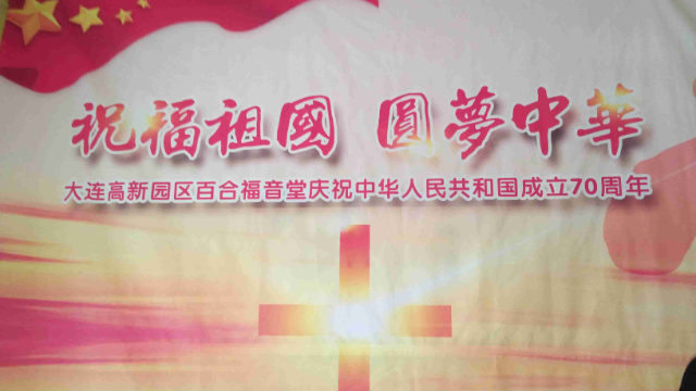 Une affiche de propagande d'Ode à la patrie et La réalisation du rêve chinois placée à l'entrée d'une église.