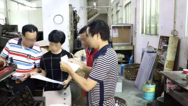 Une imprimerie de la province de Guangdong est inspectée par des fonctionnaires.