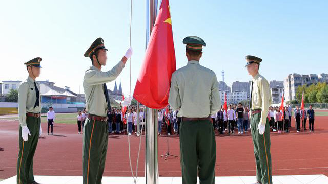 Des élèves du Xinjiang du lycée de Kou’an à Jiangsu participent à une cérémonie de lever de drapeau.