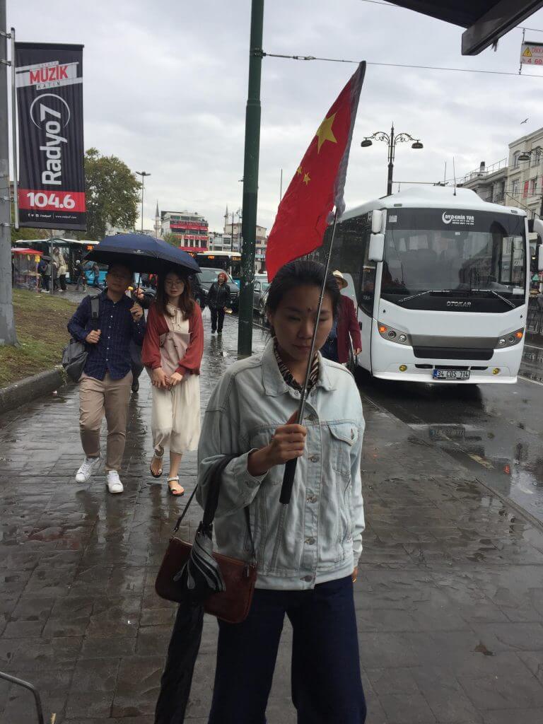 Le drapeau rouge chinois flotte haut dans les rues d’Istanbul alors qu’une guide touristique emmène son groupe de touristes dans les anciens bazars.